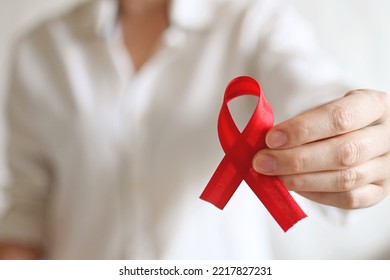 World AIDS And Hiv Day. Woman In White Shirt Holds Red Ribbon. Blood Transfusion And Donation. Hemophilia Day. World Cancer Day