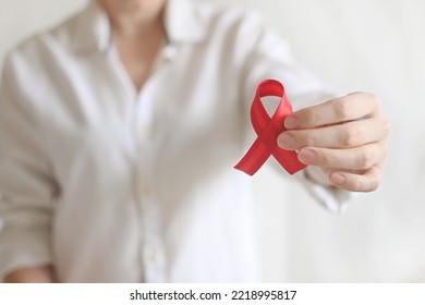 World AIDS And Hiv Day. Woman In White Shirt Holds Red Ribbon. Blood Transfusion And Donation. Hemophilia Day. World Cancer Day