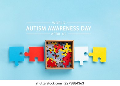 World Autism Awareness Day or month concept. Creative design for April 2. Color puzzle, symbol of awareness for autism spectrum disorder on blue background. Top view, copy space for text. 