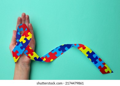 World Autism Awareness Day. Woman With Colorful Puzzle Ribbon On Cyan Background, Top View