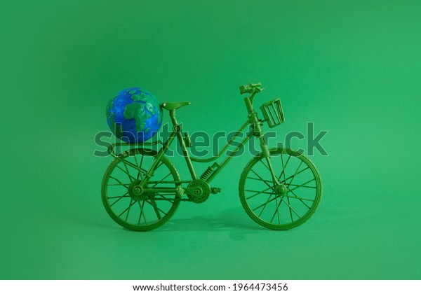 World bicycle day concept. Green bicykle with\
globe on green background. 3\
june.