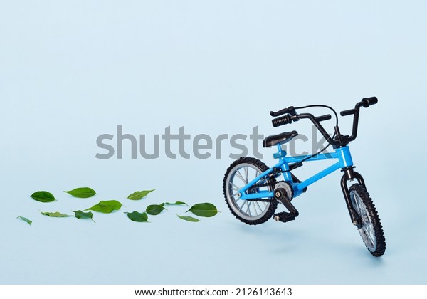 World bicycle\
day. Bicycle emitting fresh green leaves on blue background.\
Sustainable and healthy\
concept