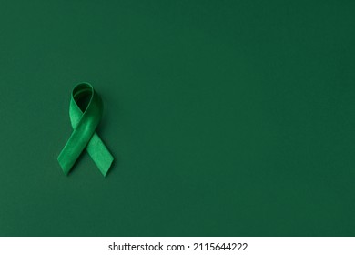 World Bipolar Day. Green Ribbon On Green Background. Mental Health Awareness Day, Depression, Cerebral Palsy. World Kidney Day. Top View. Copy Space