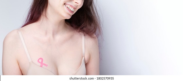 World Breast cancer day concept. Woman in bra with pink ribbon painted on her chest. October Breast Cancer Awareness month. Copy space - Powered by Shutterstock