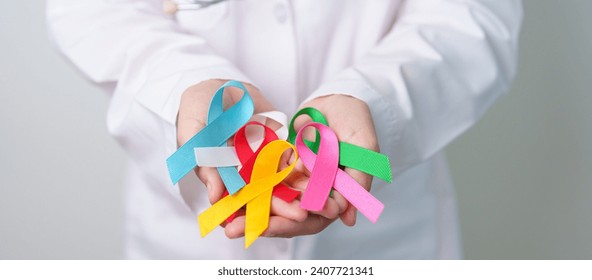 World cancer day, February 4. Doctor holding blue, red, green, white, pink, blue and yellow ribbons for supporting people living and illness. Healthcare and Autism awareness day concept - Powered by Shutterstock