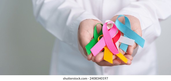 World cancer day, February 4. Doctor holding blue, red, green, white, pink, blue and yellow ribbons for supporting people living and illness. Healthcare and Autism awareness day concept - Powered by Shutterstock