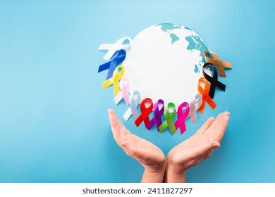 World cancer day February 4. Hand holding colorful awareness ribbons on world map. Healthcare and medical concept.Banner - Powered by Shutterstock