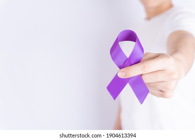 World cancer day, hands holding purple ribbon on grey background with copy space for text. Healthcare and medical concept. - Shutterstock ID 1904613394