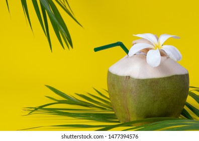 World coconut day. Fresh coconut with palm leaves on yellow table background. - Powered by Shutterstock