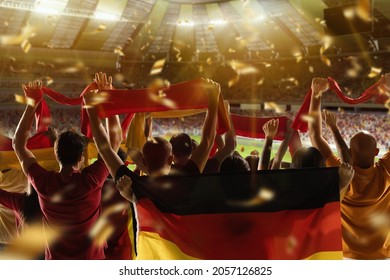 At World Cup. Back View Of Football, Soccer Fans From Germany Cheering Their Team With Black Red Yellow Flags And Scarfs At Stadium. Concept Of Sport, Support, Team Event, Competition And Fight.