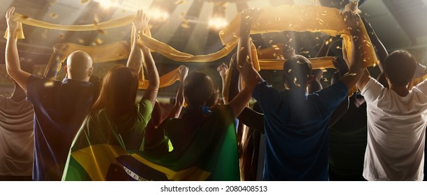 At World Cup. Back View Of Football, Soccer Fans From Brazil Cheering Their Team With Green Yellow State Flags And Scarfs At Crowded Stadium. Concept Of Sport, Support, Team Event, Competition And