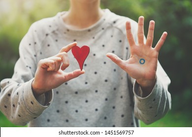 World Diabetes Day Concept, Young Woman With Blue Circle On Her Hand Holding Red Wooden Heart