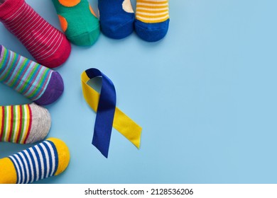 World Down syndrome day background. Down syndrome awareness concept. Socks and ribbon on blue background - Shutterstock ID 2128536206