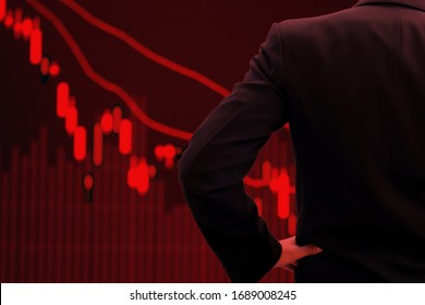 World Economy And Business In Crisis Concept. Red Tone Businessman Watching Stock Market Collapse.