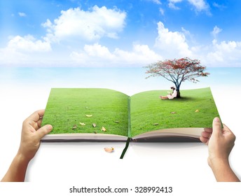 World Environment Day Concept: Human Hands Open Book Of Nature In A Beautiful Asian Children Reading Book Under Red Big Tree