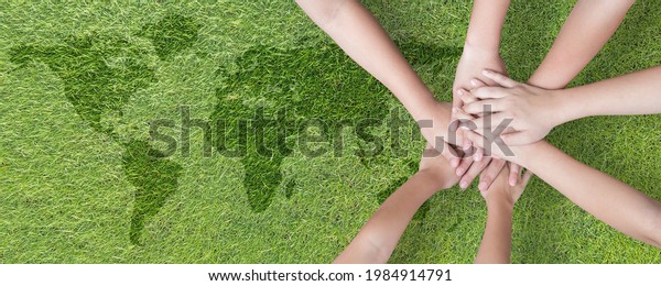 World environment day with global community\
teamwork, CSR and ESG environmental energy saving collaboration of\
young children hands stack together on green background for\
sustainable development\
goal