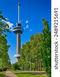 The World Famous Euromast Tower in Rotterdam Behind Cityscape With Spring Blooming Trees in The Netherlands.Vertical Orientation