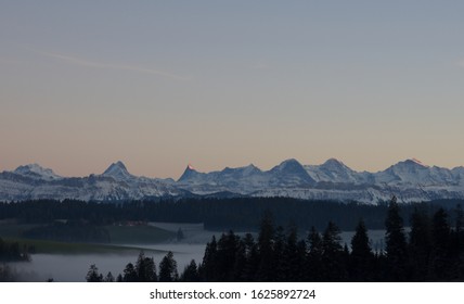 World famous mountain range of Eiger Monch and Jungfrau glowing in the evening sun