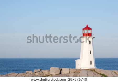 World famous Peggys Cove lighthouse on a sunny day with blue sky.