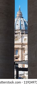 World famous Saint Peters dome seen through columns. Vatican City