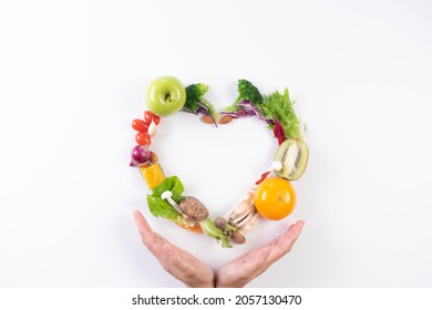 World Food Day, Vegetarian Day, Vegan Day Concept. Top View Of Woman Hand Covering Fresh Vegetables, Fruit On White Paper Background. Copy Space For Advertiser.