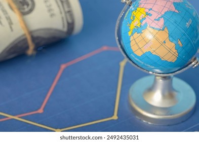 A world globe combined with a fluctuating graph and currency represents the interconnectedness of global markets and the impact of economic changes