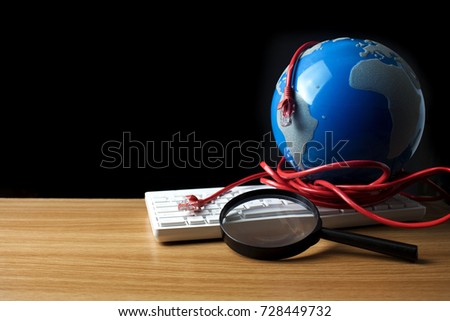 world globe with red lan wire with white keyboard and black lens