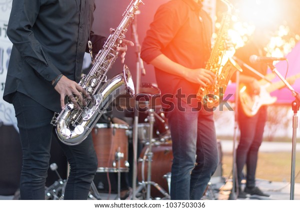 World Jazz\
festival. Saxophone, music instrument played by saxophonist player\
and band musicians on stage in\
fest.