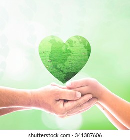 World Kindness Day Concept: Two Human Hands Holding Heart Shape Of Grass On Blurred Green Nature Background