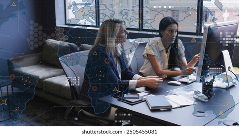 World map and data analytics image over businesswomen working in modern office. technology, teamwork, innovation, strategy, planning, digital