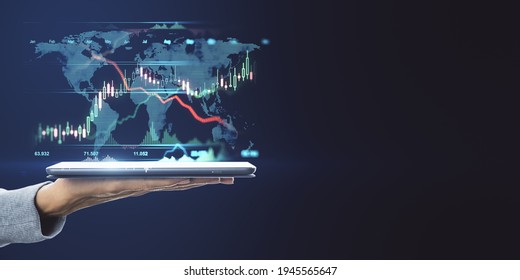 World market trading concept with digital tablet on human hand and digital financial chart graphs and world map on dark background with copyspace. Mockup - Shutterstock ID 1945565647
