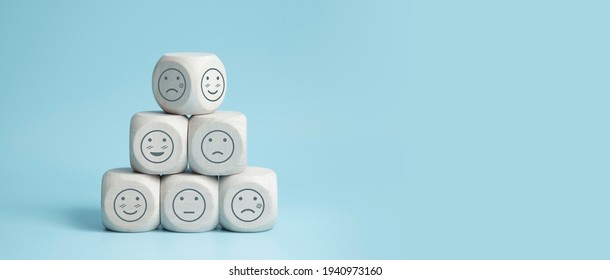 world mental health day concept or feedback rating and positive customer review, wood cube stacking with emotion face icon on blue background