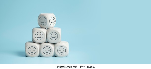 world mental health day concept or feedback rating and positive customer review, wood cube stacking with emotion face icon on blue background - Shutterstock ID 1941289036
