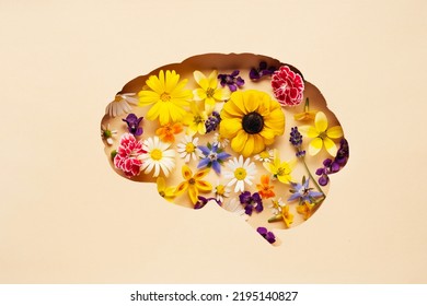 World mental health day concept. Brain symbol and flowers on a yellow background - Shutterstock ID 2195140827