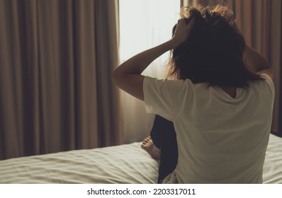 World Mental Health Day concept. Rear view of angry woman put hand on head and pulling hair. Mental illness woman sit on bed in bedroom. Woman with mental health problems. Stressed and nervous person. - Shutterstock ID 2203317011