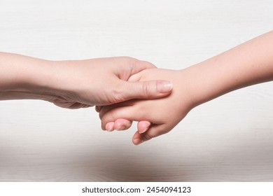 World mother day concept background. Mother and son hands close up.