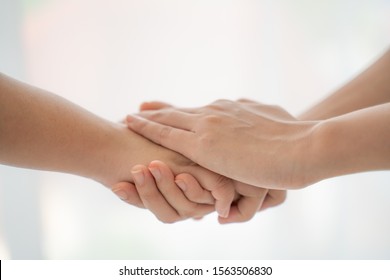 World Peace Concept.Two People Holding Hand Together Over Blurred White Background With Copy Space,Business Man And Woman Shaking Hands,helping Hand.