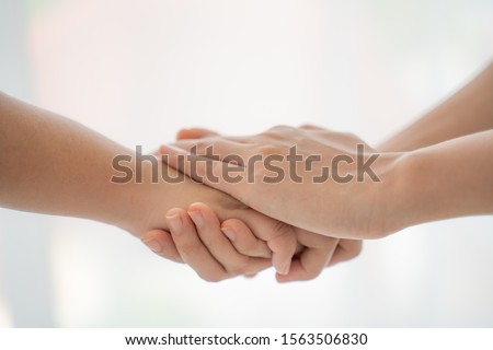 World peace concept.Two people holding hand together over blurred white background with copy space,Business man and woman shaking hands,helping hand.