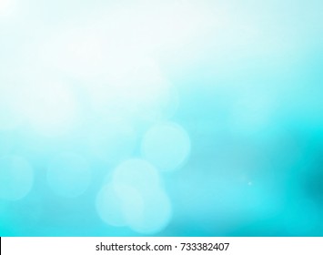World peaceful day concept: Bokeh of sunshine with abstract blurred cyan water surface background
