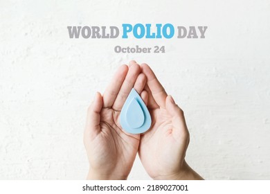 World Polio day. October 24. Blue drop in hands of an adult is symbol of polio vaccine. Poliomyelitis is disabling and life-threatening disease caused by poliovirus. - Shutterstock ID 2189027001