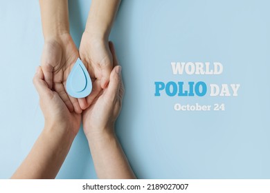 World Polio day. October 24. Blue drop in hands of an adult and child is symbol of polio vaccine. Poliomyelitis is disabling and life-threatening disease caused by poliovirus. - Shutterstock ID 2189027007