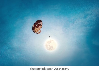 World power concept. Parachutist touches the moon at night during flight above the earth 