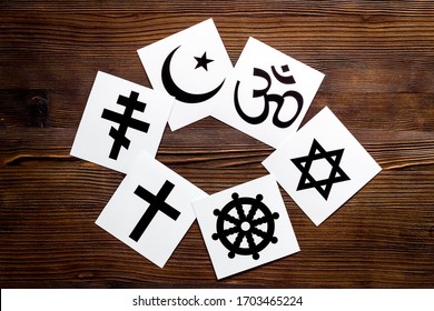 World religions concept. Christianity, Catholicism, Buddhism, Judaism, Islam symbols on wooden background top view - Shutterstock ID 1703465224