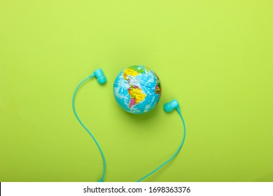 World Song. Global Music Chart. The Music Of Earth. Stereo Earphones And A Globe On Green Background. Top View