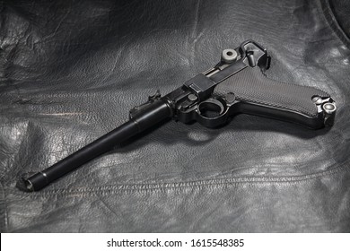 World War I period german army handgun Parabellum "Artillery Luger" on black leather jacket background