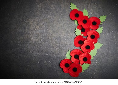 World War remembrance day. Red poppy is symbol of remembrance to those fallen in war. Red paper poppies on dark stone background