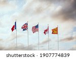 World War Two D-Day flags of allied military forces nations Canada France Great Britain and America flying at sunset on French town Arramanches Gold Beach in Normandy Europe