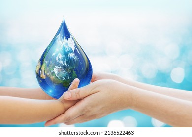 World Water Day Concept . Baby Hand And Mom Hand Holding Earth In Water Drop Shape On Blue Bokeh Background.Copy Space On Horizontal Sheet.Clipping Path.Elements Of This Image Furnished By NASA