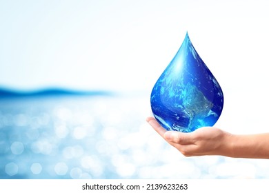 World Water Day And Global Warming Concept . A Hand Holding Earth In Water Drop Shape On Blue Sea Bokeh Background. Copy Space On Horizontal Sheet. Elements Of This Image Furnished By NASA.