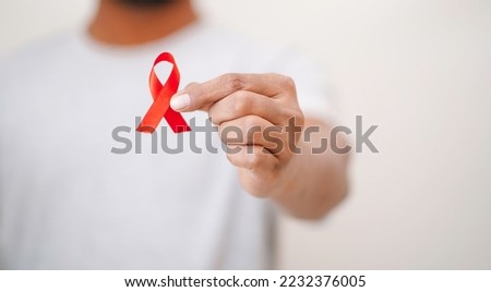Worlds HIV Aids Day, Men Holding A red ribbon In his hand, HIV Aids Awareness, Close up shot of Men Holding Red ribbon in white background HIV AIDS concept, Health Concept